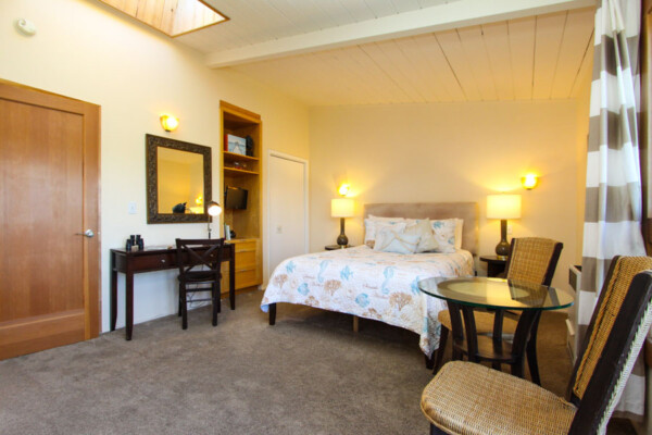room with bed, desk, tv and table with chairs